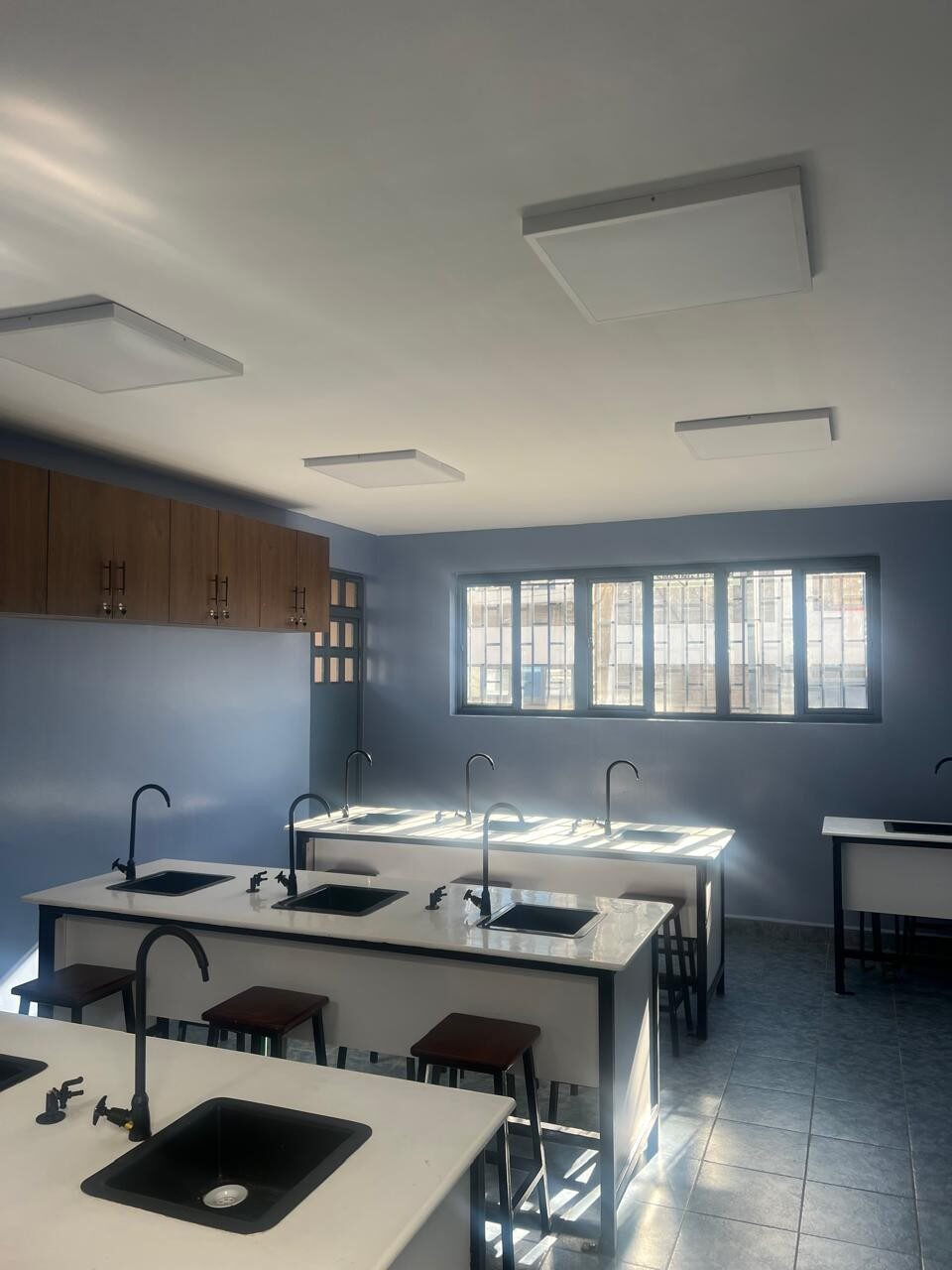 Rows of laboratory tables with sinks and timber stools