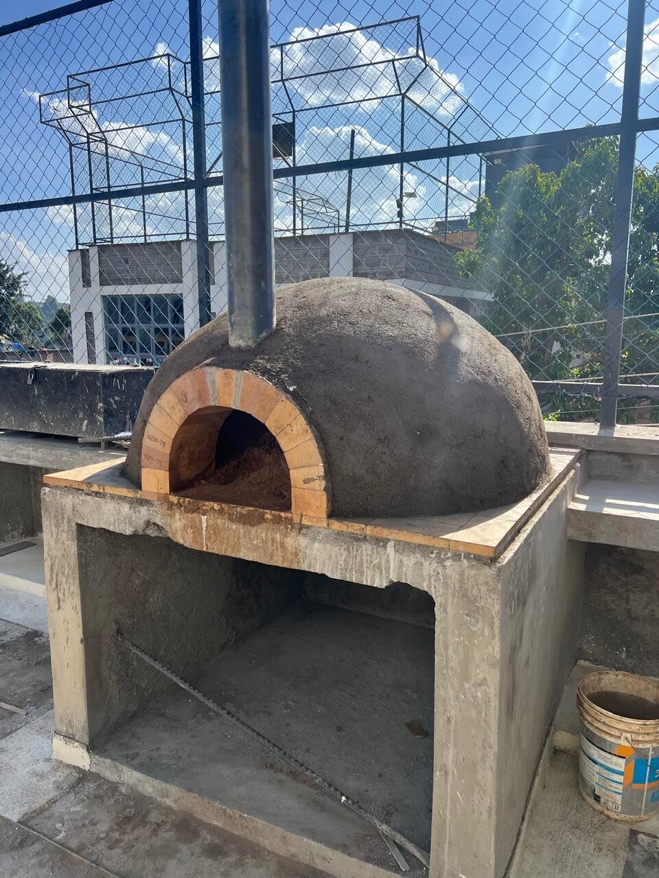 Completed wood-fired pizza oven with brick arch on the Smiling Centre rooftop