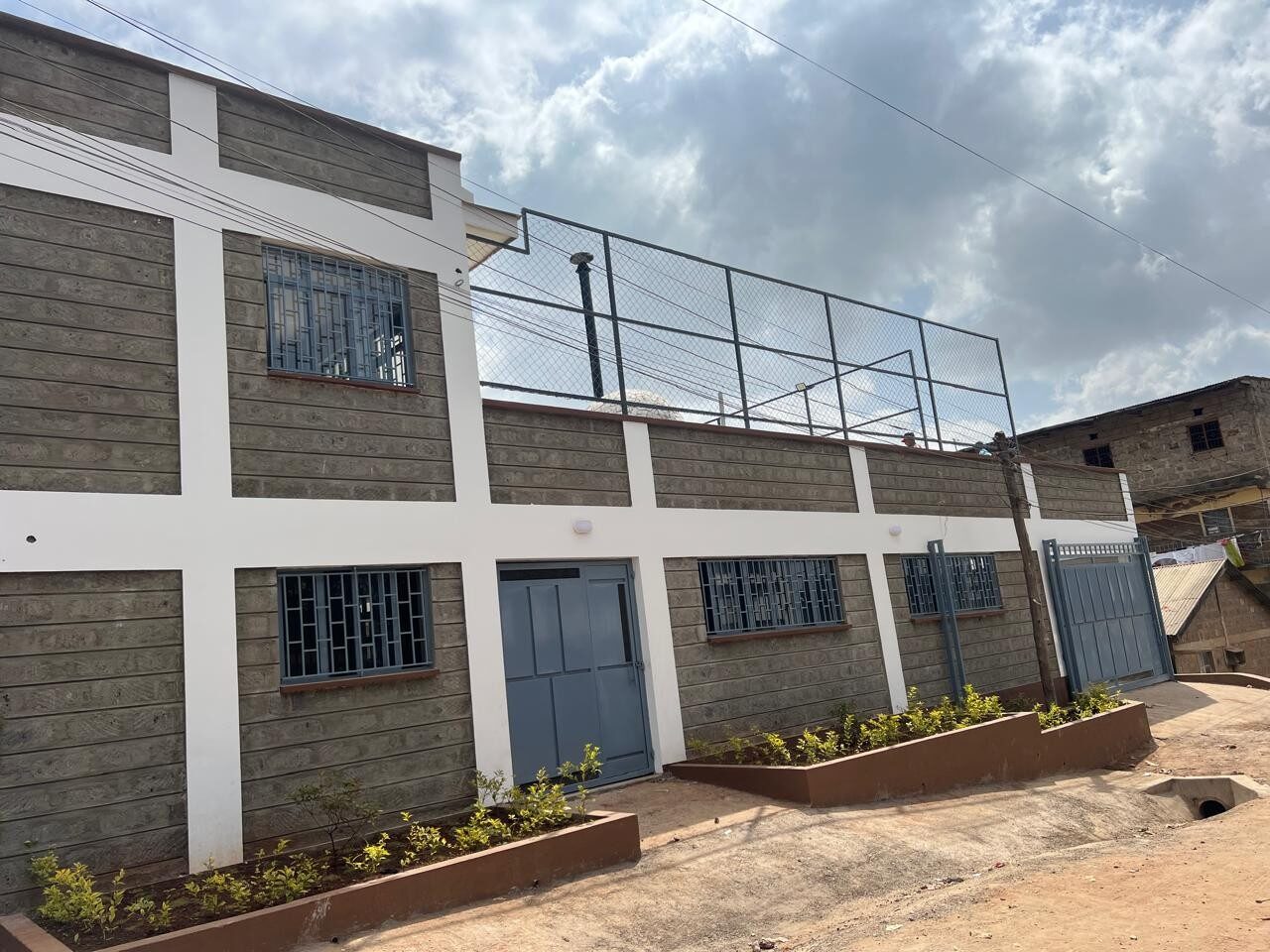 Stone-walled Smiling Centre building with fenced rooftop area